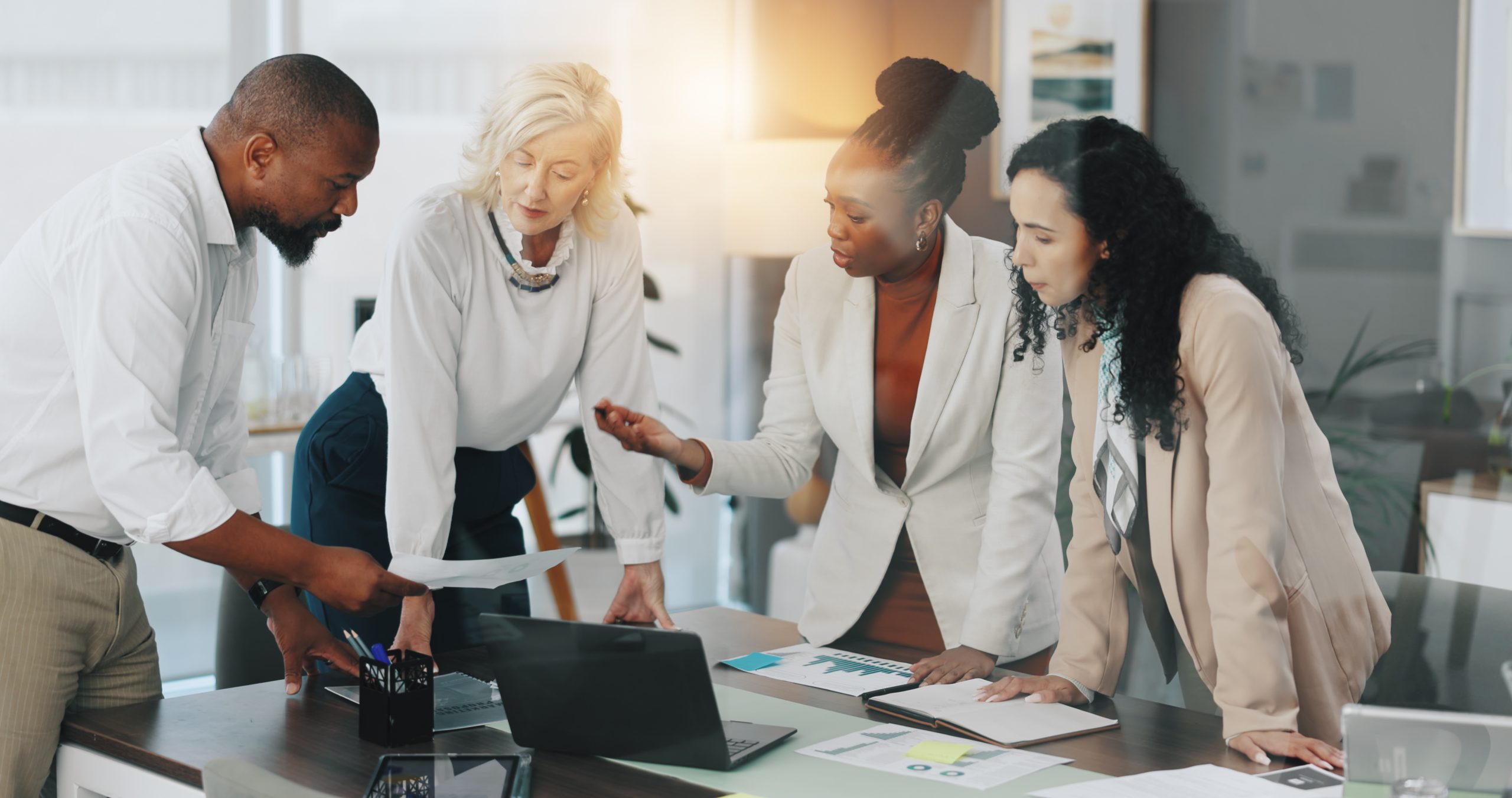 Discussion, documents and group in meeting, boardroom and ideas for market trends, speaker and planning. Business, strategy analyst and collaboration with colleagues with tech, people or conversation.