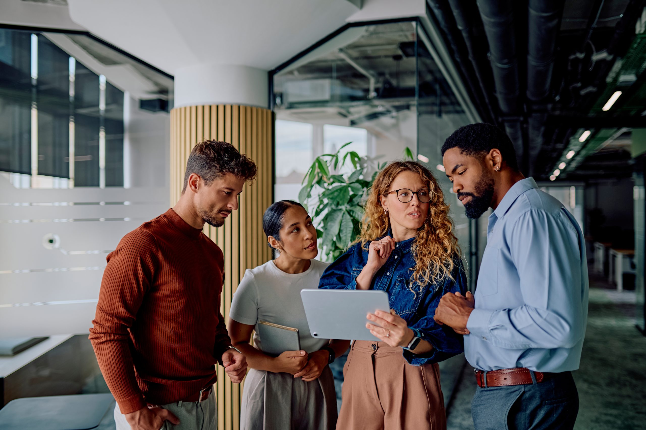 Diverse business team think and collaborate on tablet in office