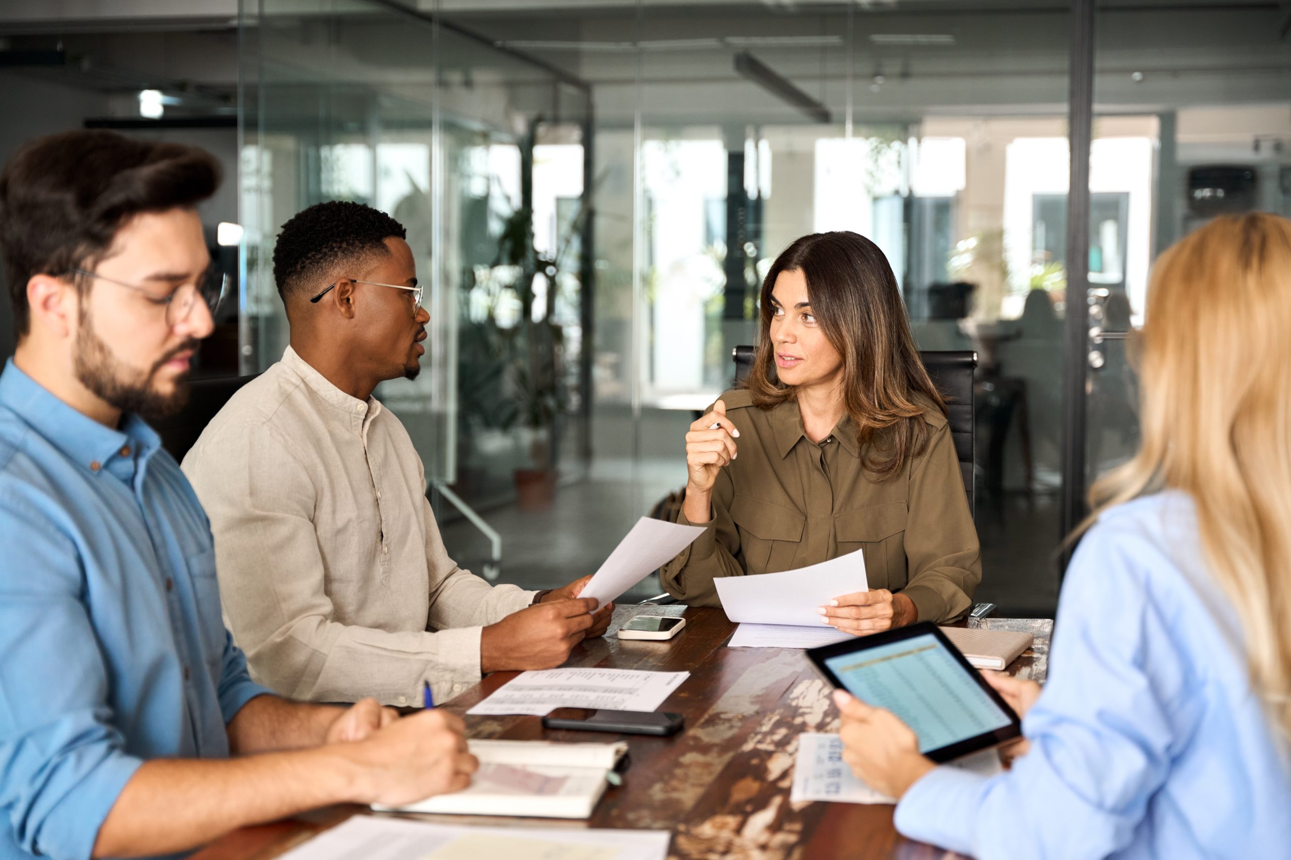 Diverse business team people having discussion at office meeting. International professional executives board group working on corporate financial strategy sitting at conference table and talking.